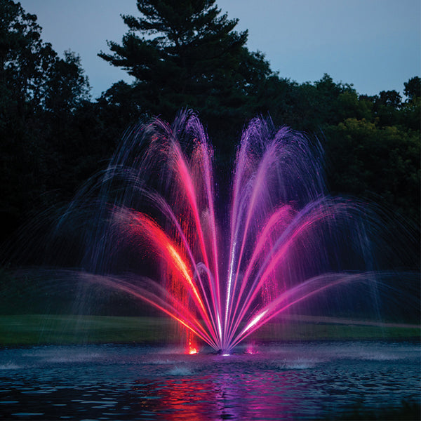 Colorful fountain show with red and purple lights in a park setting